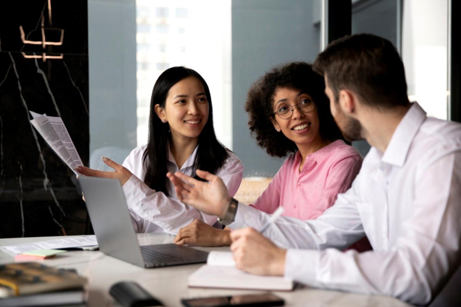 Gruppenarbeit während eines Analyseworkshops mit Laptops und Finanzberichten